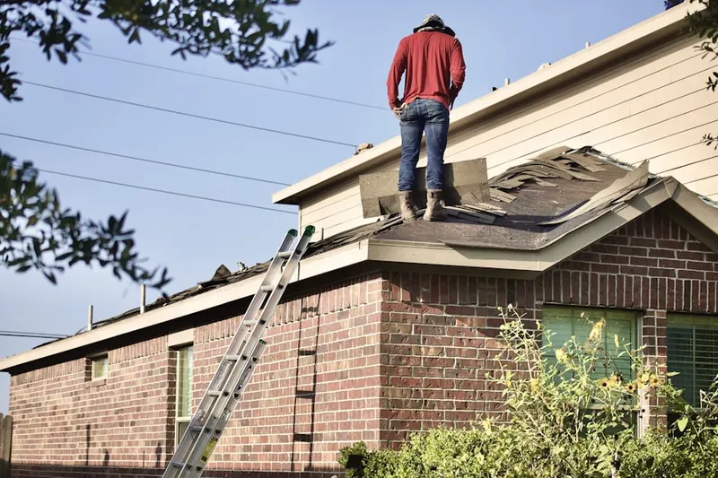 Professional roofer working on a residential roof in Center Point